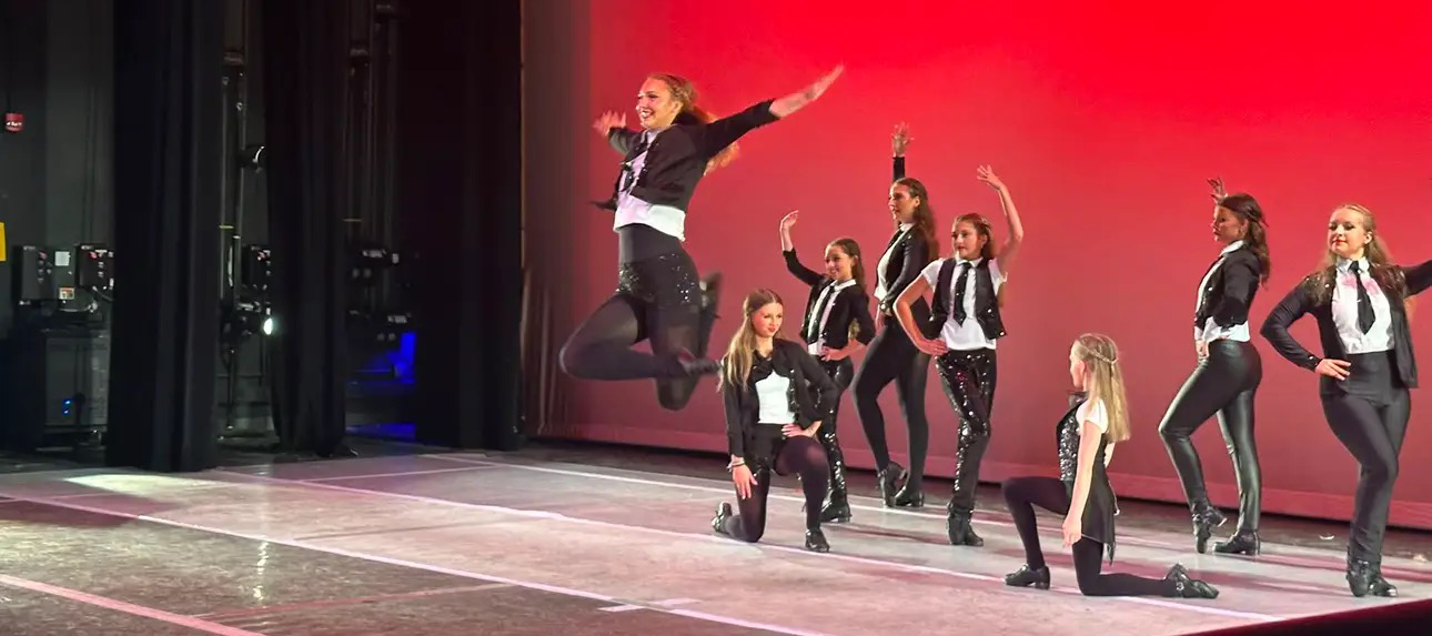 Dancer jumping on stage at recital
